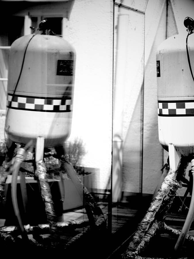 Industrial work of art Metal structures with tubes are reflected in a pane of glass.